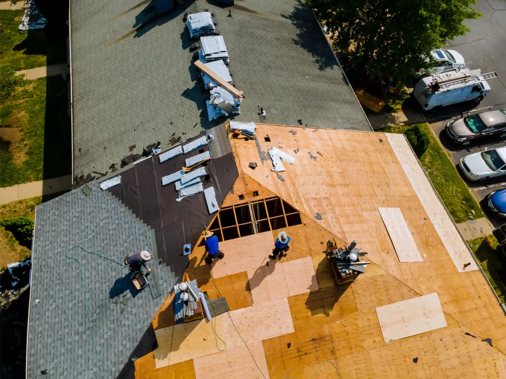 Couvreurs remplaçant la couverture d'une toiture vue du ciel, rénovation de couverture