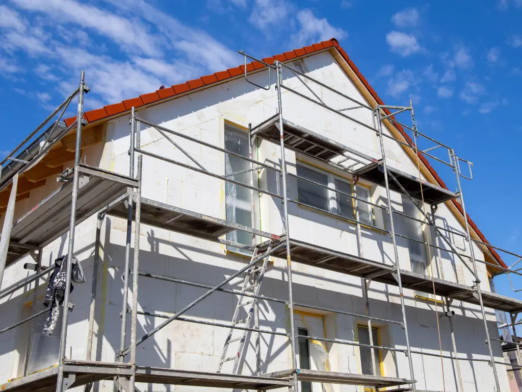 Maison sous échafaudage pendant des travaux de façade, traitement de façade