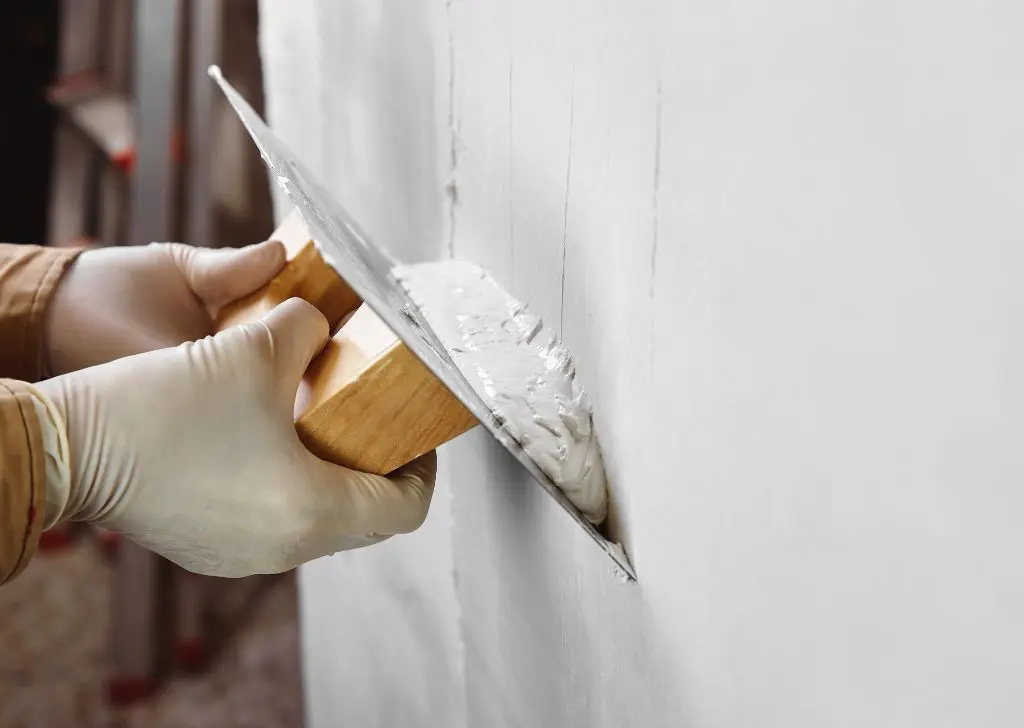 Application d'enduit sur un mur à la spatule, ravalement de façade