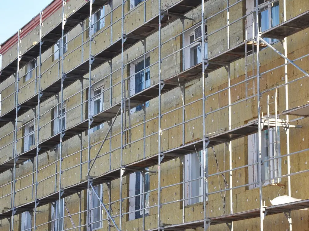 Immeuble sous échafaudage recouvert de panneaux isolants, isolation des façades